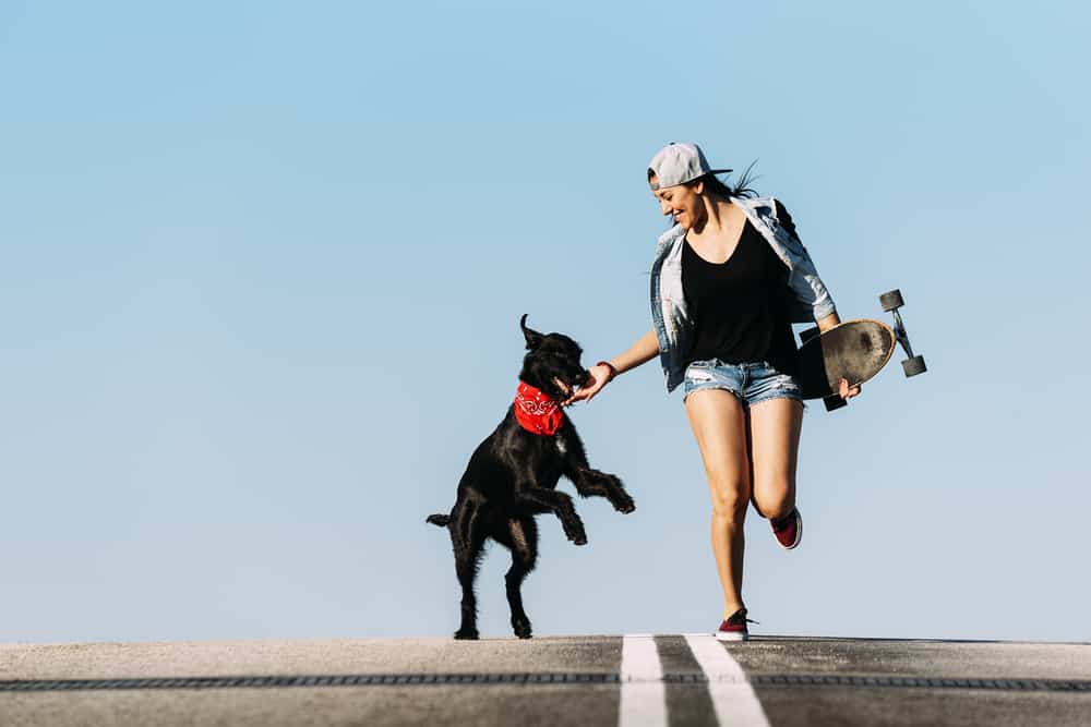 skater woman with black dog red bandana