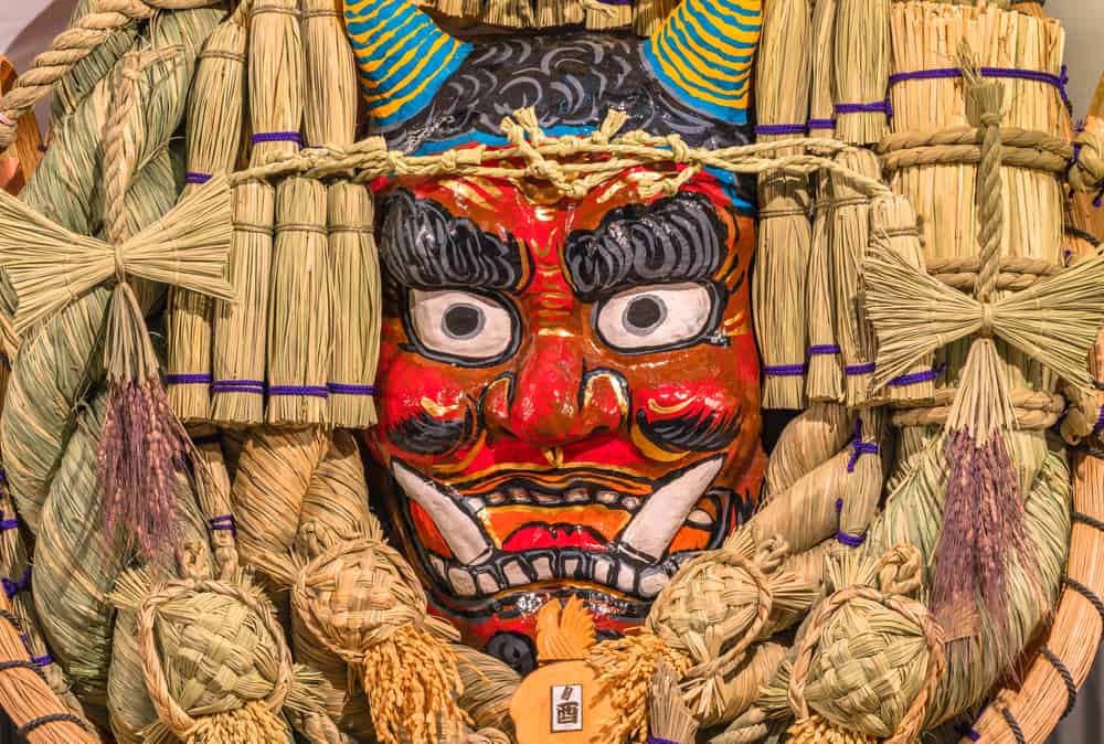 japanese demon mask surrounded by straw